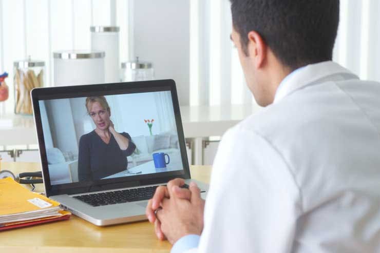 A doctor sees a patient on a video call, telemedicine