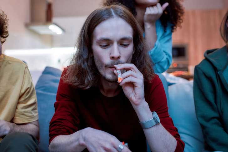 A young man smokes a joint