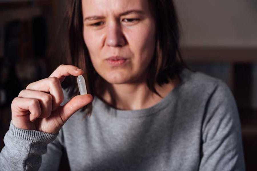 A woman examines a suppository