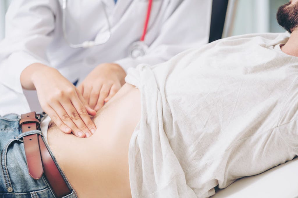 Médico realiza exame abdominal
