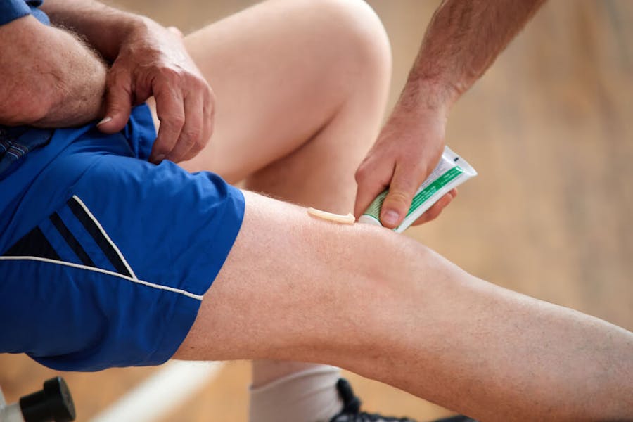 Applying cannabis balm to an injured knee of a runner