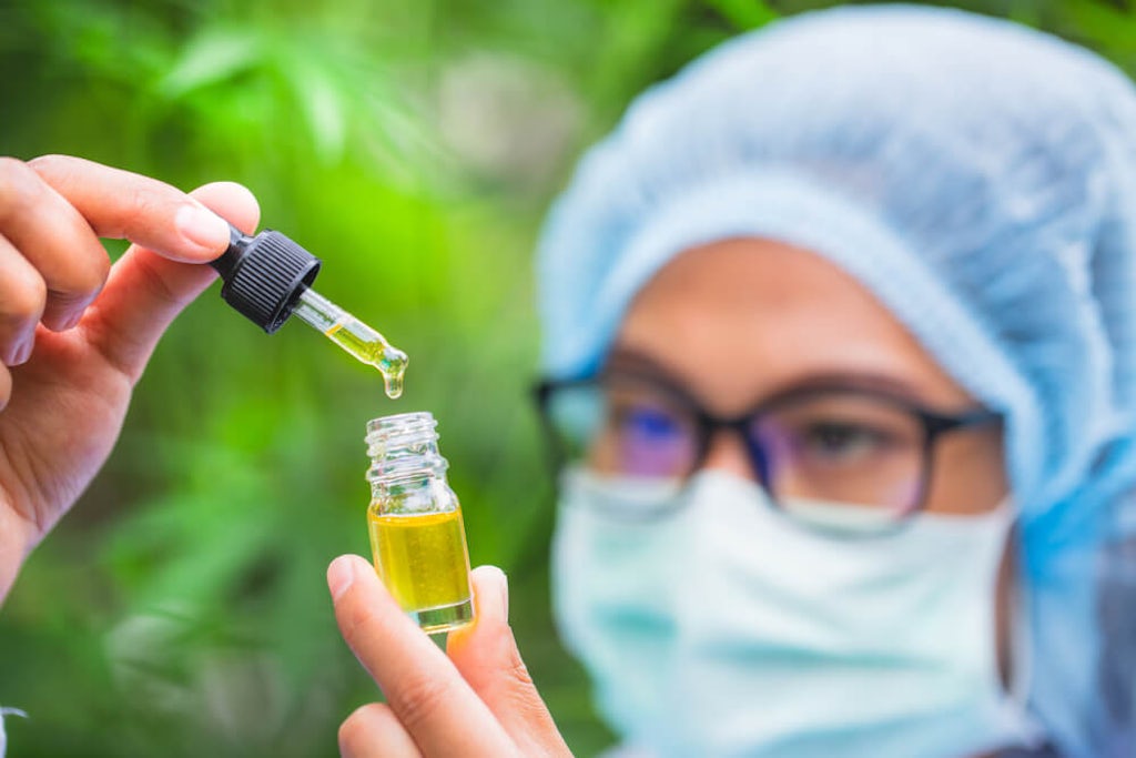 A scientist examines a bottle of CBD oil