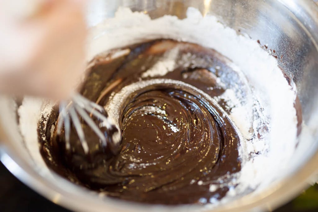 Whisking chocolate cake batter with flour