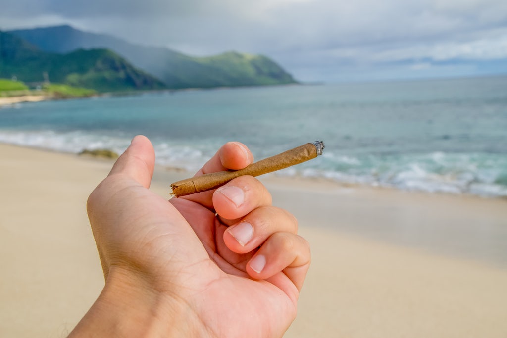 Holding a blunt on a beautiful beach