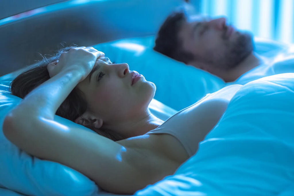 A man sleeps while a women lies awake