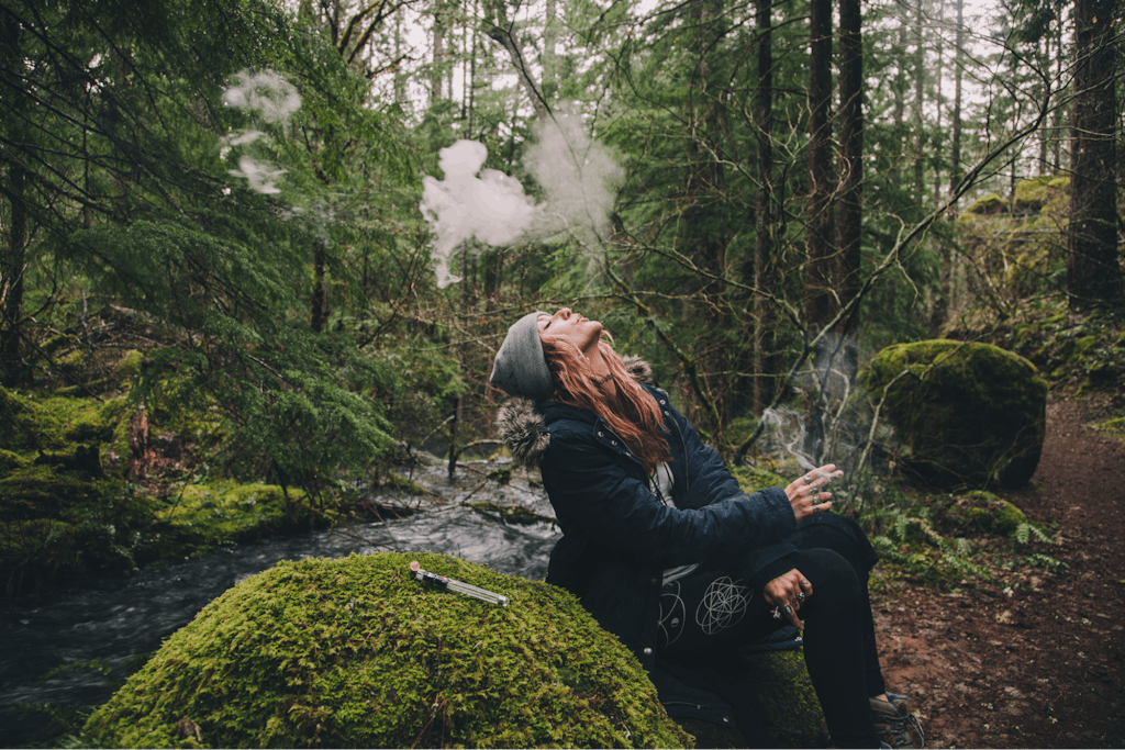 Woman smoking cannabis while hiking in the woods