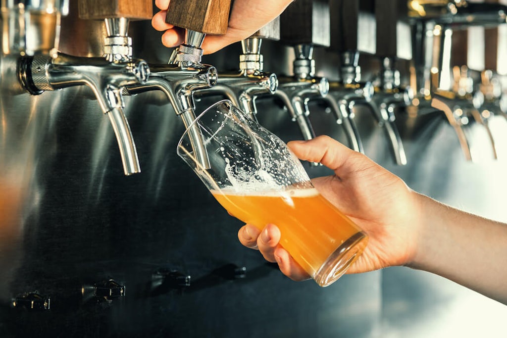 A bartender pours a beer from the tap