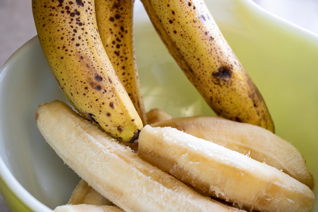 Putting bananas into a bowl to smush while preparing cannabis banana bread 