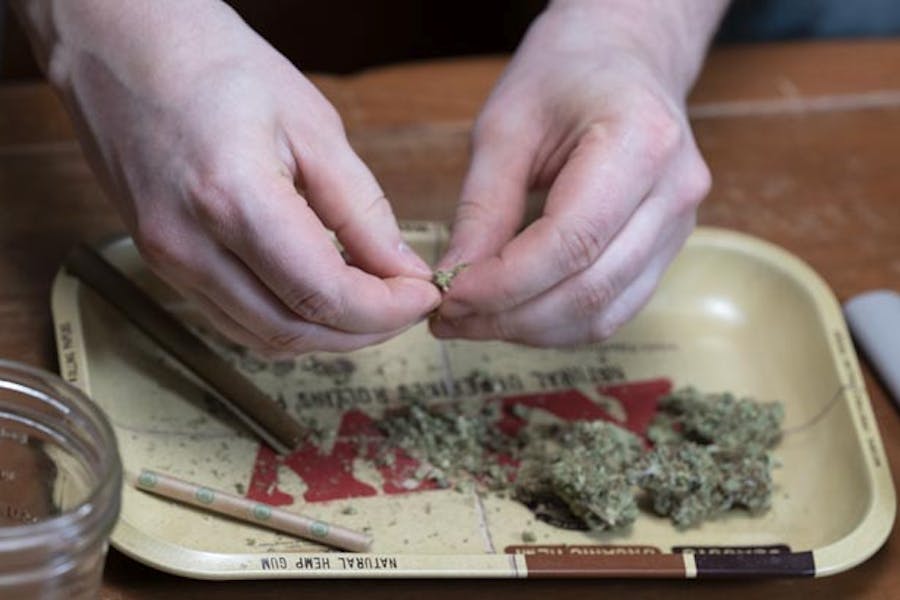 Breaking up cannabis to roll a joint