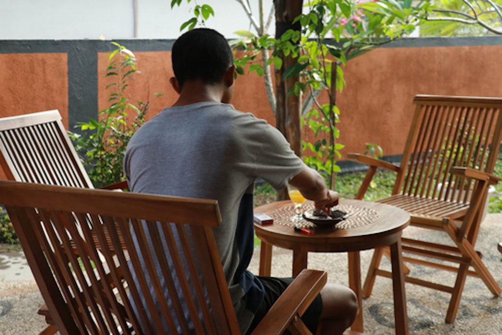 Asian young man enjoying his morning on a hotel terrace, while on vacation